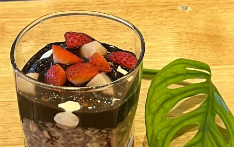 Overnight oats with strawberries and chocolate next to a leaf at Poached Breakfast Cafe Rawai, Phuket, Thailand - the answer to the question 'where to eat in rawai?'