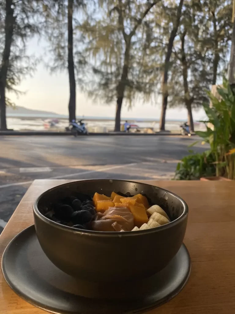 A bowl of porridge on the beach at the cafe that has the best cold brew coffee in Nai Harn: Poached Breakfast Cafe Rawai, Phuket, Thailand